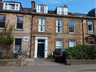 an old brick house with a car parked in front of it at the CITY- Braveheart House in Edinburgh