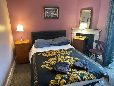 a bedroom with a bed with a blue and gold blanket at the CITY- Braveheart House in Edinburgh
