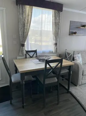 a dining table and chairs in a living room at Swift Bordeaux 73 in Dunoon