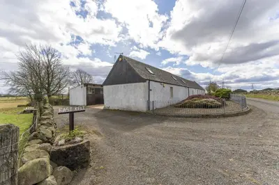 a barn on the side of a road at East Kelt Farm Cottage in Denny