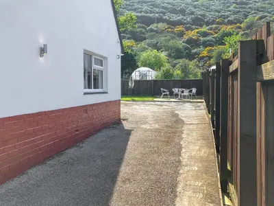 a side view of a house with a fence at Gleaner Lea Apartment in Campbeltown