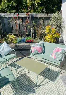 a patio with a table and two chairs and flowers at Seaview Cottage Bute in Ascog