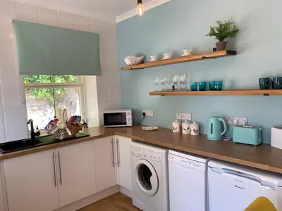 a kitchen with a washer and dryer on a counter at Seaview Cottage Bute in Ascog