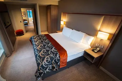 a hotel room with a large bed and a telephone at Clayton Hotel Glasgow City in Glasgow