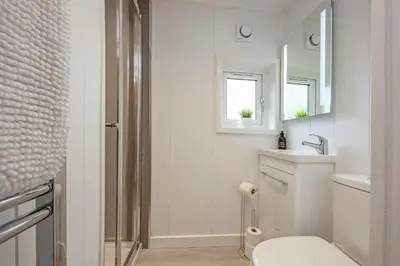 a bathroom with a toilet and a sink and a mirror at Ewe pod, luxury glamping pod with hot tub, Croft4glamping in Benderloch