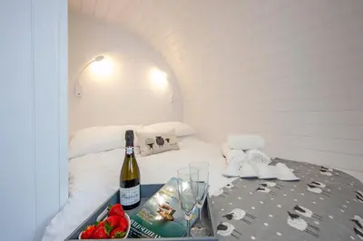 a bottle of wine on a table in a room at Ewe pod, luxury glamping pod with hot tub, Croft4glamping in Benderloch