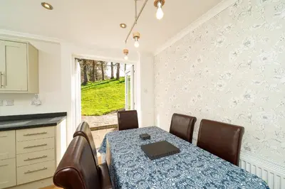 a dining room with a table and chairs and a window at Lagnaha Cottage in Kentallen