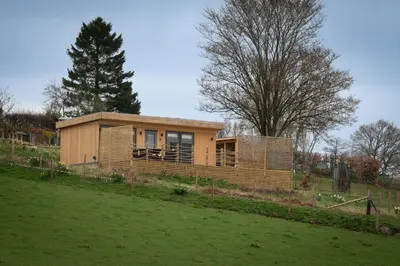 a small house in a field next to a yard at The Paddock- Loch Lomond and Trossachs in Gartmore