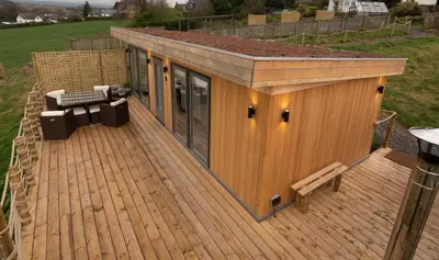 a wooden deck with a building on top of it at The Paddock- Loch Lomond and Trossachs in Gartmore