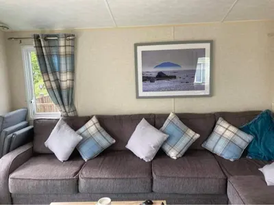a living room with a brown couch with pillows at Carnoustie 24 - Turnberry Holiday Park - short walk to beach in Girvan