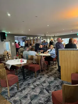 a group of people sitting at tables in a restaurant at Carnoustie 24 - Turnberry Holiday Park - short walk to beach in Girvan