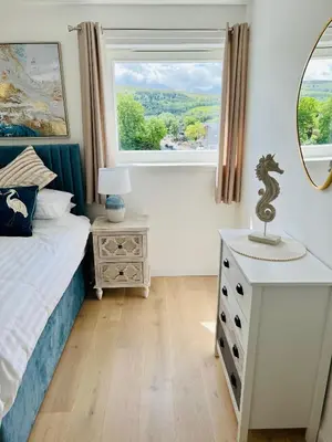 a bedroom with a bed and a window at Riverside View Penthouse in Balloch, Loch Lomond in Balloch