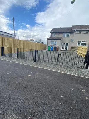 a fence on the side of a street with houses at Pure Apartments Fife - Dunfermline West in Oakley