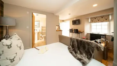 a bedroom with a large white bed with a pillow at Nether Glenny Farm in Stirling