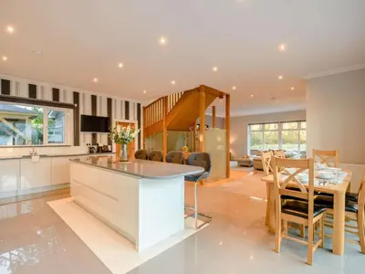 a kitchen and living room with a table and chairs at The Buckie at Buchanan - Drymen Holiday Home Sleeps 8 in Drymen