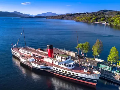 a large boat docked at a dock on a river at The Buckie at Buchanan - Drymen Holiday Home Sleeps 8 in Drymen