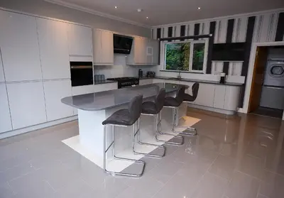 a kitchen with a counter and stools in it at The Buckie at Buchanan - Drymen Holiday Home Sleeps 8 in Drymen