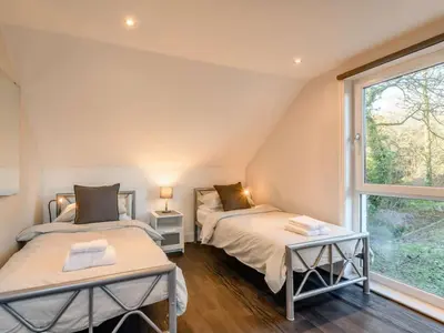 two beds in a room with a window at The Buckie at Buchanan - Drymen Holiday Home Sleeps 8 in Drymen
