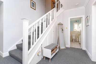 a white hallway with a staircase with a toilet at NEW Four Bedroom House - all rooms ensuite in Stirling