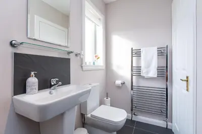 a white bathroom with a sink and a toilet at NEW Four Bedroom House - all rooms ensuite in Stirling