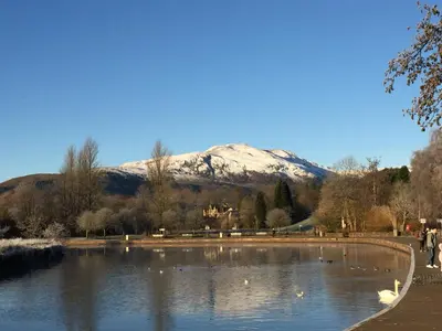 a lake with a snow covered mountain in the background at Tanllan Apartment in Callander
