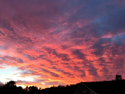 a sunset with red clouds in the sky at Tanllan Apartment in Callander