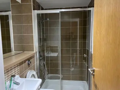 a bathroom with a shower and a sink and a toilet at Modern & Spacious 2 bed Merchant City Apart-High St in Glasgow