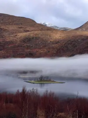 a small island in the middle of a body of water at Riverside Pod, West Highland Way Holidays in Kinlochleven