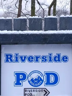a sign for riversidepd with snow on it at Riverside Pod, West Highland Way Holidays in Kinlochleven