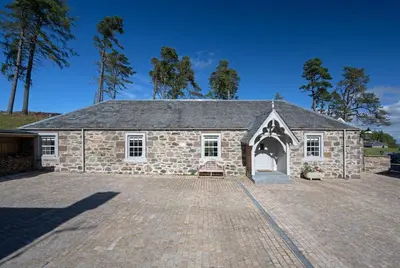 a stone church with a large driveway in front of it at Stables Cottage in Perth