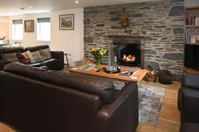 a living room with a couch and a fireplace at Laverockbank Farmhouse in Perth