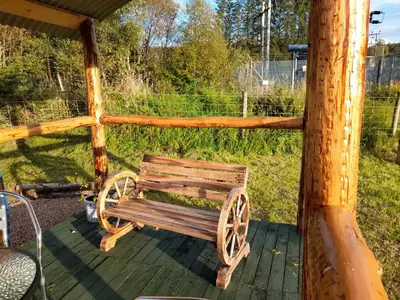 a wooden bench sitting on a wooden deck at Sunset View Shepherds Hut in Dalmally