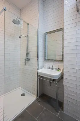 a bathroom with a sink and a shower with a mirror at Coach House in Perth