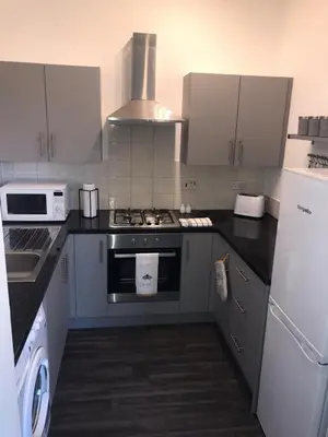 a kitchen with a stove and a stove top oven at Vogue Apartments in Glasgow