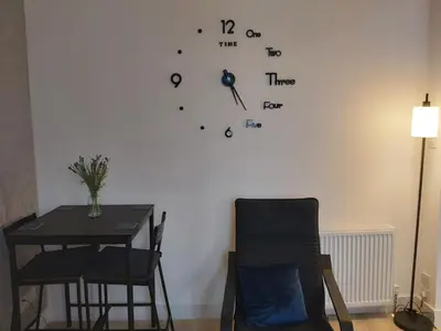 a room with a table and a clock on the wall at One bedroom flat, very close to Town center. in Oban