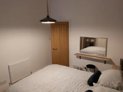 a bedroom with a bed and a mirror on the wall at One bedroom flat, very close to Town center. in Oban