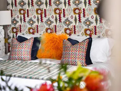 a bedroom with a bed with pillows and a wall at The Meadowpark Bar, Kitchen & Rooms in Stirling