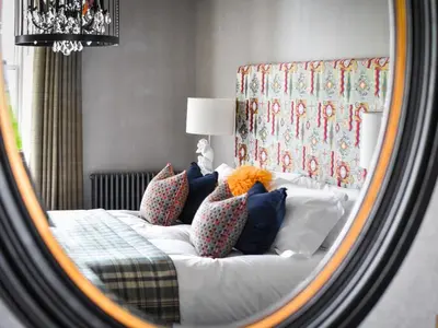 a reflection of a bed with pillows in a mirror at The Meadowpark Bar, Kitchen & Rooms in Stirling