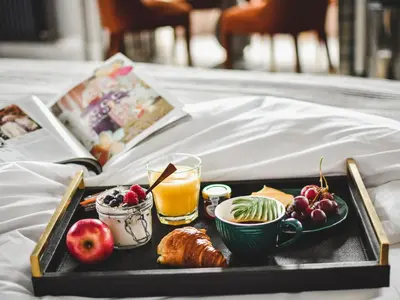 a tray of food with fruit and a glass of orange juice at The Meadowpark Bar, Kitchen & Rooms in Stirling
