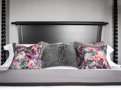 a bed with two pillows and a black headboard at The Meadowpark Bar, Kitchen & Rooms in Stirling