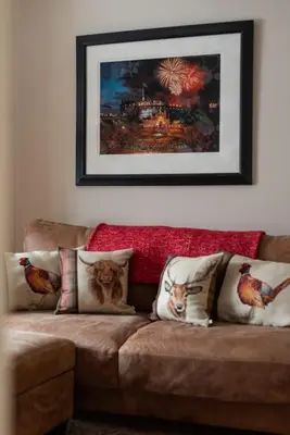 a couch with pillows and a picture on the wall at Charming Grassmarket 1 Bed Castle pad in Edinburgh