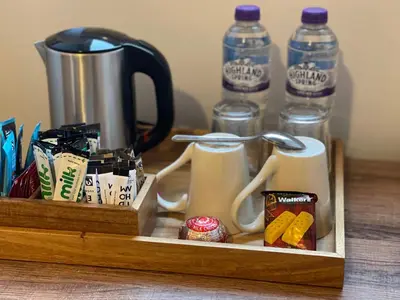 a wooden tray with two mugs and two bottles of water at Killorn Guest House in Oban