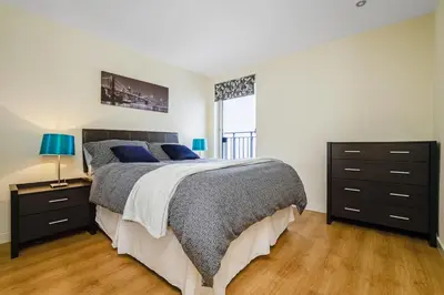 a bedroom with a large bed with blue pillows at Bell Street Apartments in Glasgow