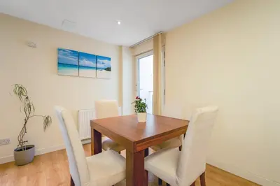 a dining room with a wooden table and chairs at Bell Street Apartments in Glasgow