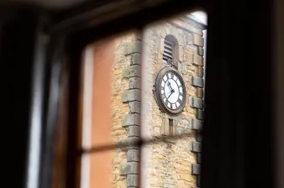 a clock on the side of a brick tower at The Tollbooth in Clackmannan
