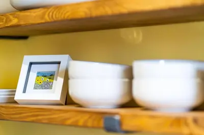 a shelf with three white bowls and a picture at The Tollbooth in Clackmannan