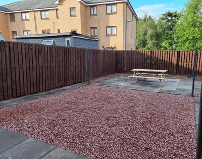 a backyard with a wooden fence and a bench at Hamilton Home From Home in Hamilton