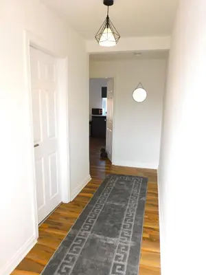 an empty hallway with a rug on the floor at Newly refurbished 2 bedroom apartment close to station and local amenities in Hamilton