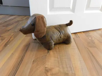 a small wooden dog sitting on the floor next to a door at Newly refurbished 2 bedroom apartment close to station and local amenities in Hamilton