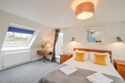 a bedroom with a large bed and a window at Blackmount House in Oban